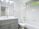 Clean bathroom with white tile, a gray vanity, and a bright window at 101 Sandpebble Pl, Sanford, FL 32771