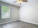Comfortable bedroom featuring wood-look flooring, ceiling fan, and a bright window at 101 Sandpebble Pl, Sanford, FL 32771