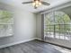 Bright bedroom featuring wood-look flooring, ceiling fan, and a large arched window at 101 Sandpebble Pl, Sanford, FL 32771