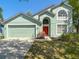 Charming two-story home featuring a red front door, well-maintained lawn, and an attached two-car garage at 101 Sandpebble Pl, Sanford, FL 32771