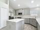 Modern kitchen with stainless steel appliances, center island, and gray cabinets at 101 Sandpebble Pl, Sanford, FL 32771