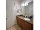 Bathroom vanity with a granite countertop, wood cabinets, a modern faucet, and decorative wall art at 12184 Aztec Rose Ln, Orlando, FL 32827