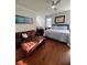Comfortable bedroom with a leather sofa, bed, and a ceiling fan on hardwood floors, designed for relaxation at 12184 Aztec Rose Ln, Orlando, FL 32827