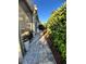 The exterior shows a stone walkway, lush landscaping, and privacy hedges surrounding the home at 12184 Aztec Rose Ln, Orlando, FL 32827