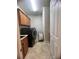 Laundry room with modern black washer/dryer, storage cabinets and tile flooring at 12184 Aztec Rose Ln, Orlando, FL 32827