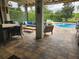 Covered patio with plush outdoor seating, a built-in grill, and a serene view of the sparkling pool at 12184 Aztec Rose Ln, Orlando, FL 32827
