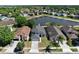 Aerial view of the home with a pond view, green lawns and mature trees at 12613 Maribou Cir, Orlando, FL 32828
