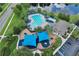 Aerial view of the community pool, playground, and clubhouse surrounded by mature trees and landscaping at 12613 Maribou Cir, Orlando, FL 32828