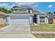Charming two-story home features a two-car garage, manicured lawn, and inviting front entrance with decorative wreath at 12613 Maribou Cir, Orlando, FL 32828