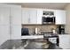 Kitchen area showcasing white cabinets, stainless appliances, and backsplash at 12613 Maribou Cir, Orlando, FL 32828