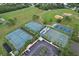 Aerial view of well-maintained tennis and basketball courts with ample parking and green surroundings at 12613 Maribou Cir, Orlando, FL 32828