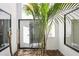Lush atrium features tropical plants and natural light streaming through sliding glass doors at 1311 Harbour Dr, Longwood, FL 32750