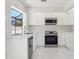 Well-lit kitchen equipped with stainless steel appliances, white cabinets and modern fixtures at 1311 Harbour Dr, Longwood, FL 32750