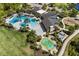 Aerial view of community featuring pool, splash pad, playground, clubhouse, and green space at 17668 Passionflower Cir, Clermont, FL 34714