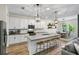 Modern kitchen with white cabinets, a large center island, and open views to the dining area at 17668 Passionflower Cir, Clermont, FL 34714