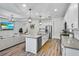 Open concept kitchen with white cabinets, large island, stainless appliances, and seamless flow to living area at 17668 Passionflower Cir, Clermont, FL 34714