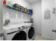 Well-organized laundry room with modern washer and dryer, ample shelving, and laundry-themed decor at 17668 Passionflower Cir, Clermont, FL 34714