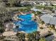 Overhead view of a large community pool, splashpad, clubhouse and tennis courts for recreation at 1807 Good Neighbor Loop, Kissimmee, FL 34744