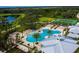 Aerial view of a sparkling community pool, splashpad, tennis courts and surrounding green space for recreation at 1807 Good Neighbor Loop, Kissimmee, FL 34744