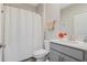 Clean bathroom with white shower curtain, grey vanity, and wood-look flooring at 1807 Good Neighbor Loop, Kissimmee, FL 34744