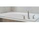 Close-up of the elegant soaking tub with a brushed nickel faucet set and tile surround at 1807 Good Neighbor Loop, Kissimmee, FL 34744