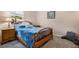 Cozy bedroom with a plush blue comforter, a wood frame, and a three-drawer nightstand at 1807 Good Neighbor Loop, Kissimmee, FL 34744