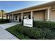 The clubhouse entrance features a manicured lawn, welcoming entryway, and sign for the community gathering place at 1807 Good Neighbor Loop, Kissimmee, FL 34744