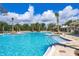 A large, sparkling community pool with lounge chairs and palm trees offers a resort-style experience at 1807 Good Neighbor Loop, Kissimmee, FL 34744