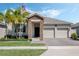 Inviting home featuring a stone facade, well-maintained lawn, and a convenient two-car garage at 1807 Good Neighbor Loop, Kissimmee, FL 34744