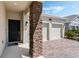 Close-up of a home's exterior showcasing the stone pillar, front door, and brick driveway at 1807 Good Neighbor Loop, Kissimmee, FL 34744