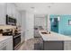 Bright kitchen features stainless steel appliances, gray cabinetry, a kitchen island, and a modern cooktop at 1807 Good Neighbor Loop, Kissimmee, FL 34744