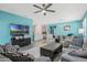 Open-concept living area with stylish furniture, a large TV, and a ceiling fan at 1807 Good Neighbor Loop, Kissimmee, FL 34744