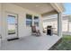 The covered back patio has a grill and seating with a view of the backyard at 1807 Good Neighbor Loop, Kissimmee, FL 34744