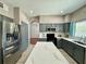 Modern kitchen with stainless steel refrigerator, gray cabinets, a center island with a quartz countertop, and a window at 2014 Applegate Dr, Ocoee, FL 34761