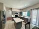 Well-lit kitchen with stainless steel appliances, gray cabinets, an island with a quartz countertop, and an eat-in area at 2014 Applegate Dr, Ocoee, FL 34761