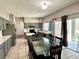 Spacious eat-in kitchen with stainless steel appliances, gray cabinets, an island, an eat-in table, and access to the patio at 2014 Applegate Dr, Ocoee, FL 34761