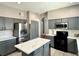 Modern kitchen featuring stainless steel appliances, a center island with a quartz countertop, and gray cabinets at 2014 Applegate Dr, Ocoee, FL 34761