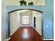 Cozy living room with hardwood flooring, and inviting archway with plants above leading to another room at 2014 Applegate Dr, Ocoee, FL 34761