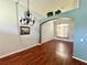 Cozy living room with stylish chandelier, hardwood flooring, and inviting archway with plants above at 2014 Applegate Dr, Ocoee, FL 34761