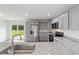 Granite kitchen island with stainless appliances, gray cabinets, and granite countertops at 20661 Sw Marine Blvd, Dunnellon, FL 34431