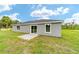 Rear exterior view featuring windows and sliding glass door leading to the backyard at 21145 Sw Great Lakes Blvd, Dunnellon, FL 34431