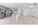 Open kitchen view with gray cabinets, stainless steel appliances and light wood flooring at 21145 Sw Great Lakes Blvd, Dunnellon, FL 34431