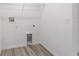 Bright laundry room with white walls and trim, featuring wood-look vinyl flooring and convenient utility connections at 21145 Sw Great Lakes Blvd, Dunnellon, FL 34431