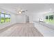Open floorplan with wood-look floors, a ceiling fan, breakfast bar and a view at 21145 Sw Great Lakes Blvd, Dunnellon, FL 34431