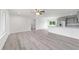 An open-concept living space with neutral walls, wood-look floors, and a modern kitchen with stainless steel appliances at 21145 Sw Great Lakes Blvd, Dunnellon, FL 34431