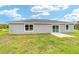 A single-story home with sliding glass door and white frame windows set against a lush green lawn and cloudy sky at 21145 Sw Great Lakes Blvd, Dunnellon, FL 34431