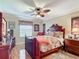 Bedroom with hardwood floors, a ceiling fan, and a decorative bed frame and matching furniture at 2124 Westchester Way, The Villages, FL 32162