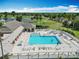 Resort-style pool featuring lounge chairs, palm trees and lush landscaping at 2124 Westchester Way, The Villages, FL 32162