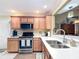 This kitchen features a stainless steel range and microwave, quartz countertops and wood cabinets at 2124 Westchester Way, The Villages, FL 32162