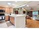 Well-appointed kitchen offering quartz counters, stainless appliances, and bar-style seating overlooking the living area at 2124 Westchester Way, The Villages, FL 32162